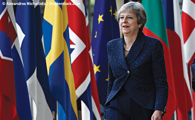 Theresa May in front of EU flags